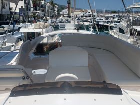 A spacious interior view of a boat's lounge area, featuring comfortable seating and a sleek design, perfect for relaxing while on the water.