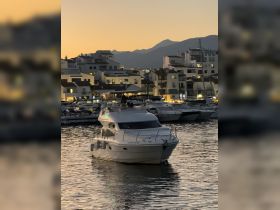 A beautiful yacht docked at sunset, surrounded by a picturesque marina — perfect for evening cruises and relaxation.