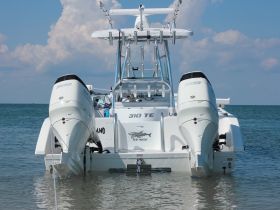 A striking rear view of a center console boat, showcasing its powerful twin engines and sleek design, perfect for fishing or cruising in open waters.