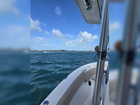 A scenic view from the bow of a boat, showcasing the vibrant blue waters and a distant shoreline under a clear sky — perfect for a day out on the water.