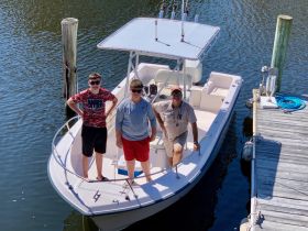 A group of friends poses on a fishing boat, ready for a day of adventure on the water. Perfect for family outings or fishing trips.
