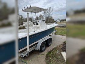 A side view of a Sea Hunt boat docked on a trailer, showcasing its sleek design and features — perfect for fishing or leisure outings.