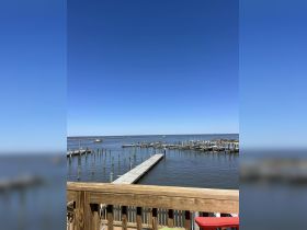 A view of a marina with docks and calm waters under a clear blue sky, perfect for boating enthusiasts and waterfront activities.