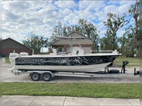 A side view of the 'Southern Angler' boat, showcasing its sleek design while docked on a paved surface, ideal for fishing enthusiasts.