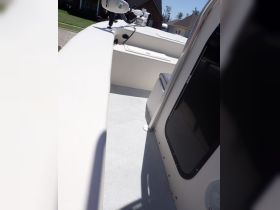 A detailed view of the interior helm and seating area of a boat, showcasing the clean and functional design ideal for navigation and comfort.