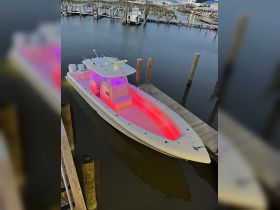 A sleek speedboat docked with vibrant lighting, showcasing its modern design and perfect for evening outings on the water.