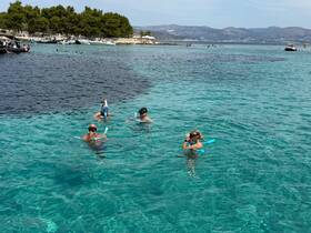 A group of snorkelers enjoys the crystal-clear waters, showcasing the vibrant marine life in a picturesque setting — perfect for adventure seekers and beach lovers.