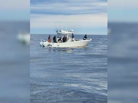 A group of anglers enjoys a day of fishing on a boat in the open ocean, showcasing the excitement of a fishing adventure.
