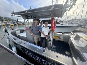 A cheerful group poses aboard a fishing charter boat at the marina, ready for an exciting day on the water.