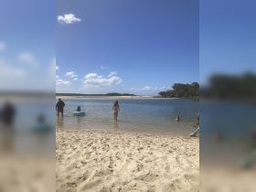 A lively beach scene with people enjoying the water and sun, perfect for family outings and summer fun.