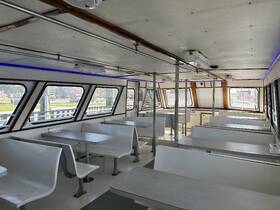 Interior view of a spacious boat cabin featuring modern seating arrangements, perfect for dining or gatherings while cruising.