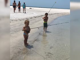 Two children enjoy a fun day of fishing at the beach, creating cherished family memories in the sun.