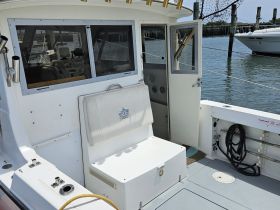 Interior view of a boat's helm and seating area, showcasing the functional layout ideal for navigation and comfort.