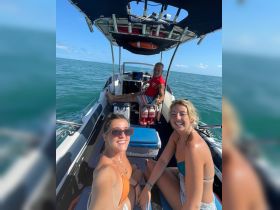 A cheerful group enjoys their time aboard a boat, capturing the moment with smiles and camaraderie on the water.