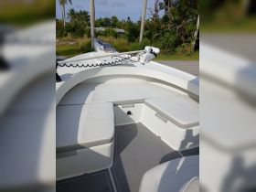 Interior view of a boat's seating area, showcasing comfortable cushions and a clean helm space, perfect for relaxing while on the water.