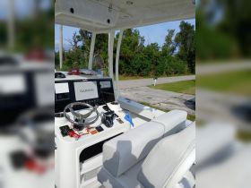 A well-equipped helm area of a boat featuring a steering wheel, console, and comfortable seating, ideal for navigating the waters.