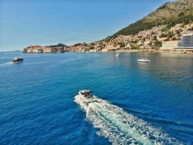 A picturesque view of boats navigating the clear blue waters near the stunning coastline of Dubrovnik, showcasing the beauty of sailing in this historic region.