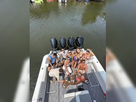 A lively group enjoys drinks and fun on the deck of a boat, capturing the essence of a perfect day on the water with friends.