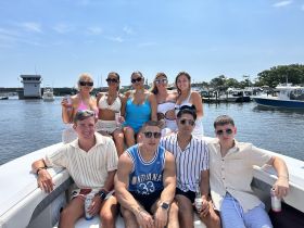 A lively group of friends enjoys a sunny day on the boat, celebrating with drinks and laughter — perfect for summer outings and memorable gatherings.
