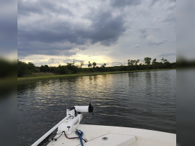 A serene view of a boat on calm waters under a cloudy sky, showcasing the tranquil beauty of nature — perfect for peaceful outings.