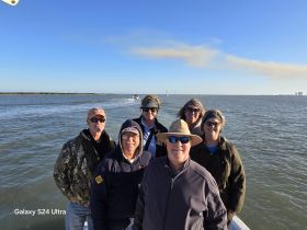A cheerful group of friends poses together on a boat, enjoying a sunny day on the water — perfect for memorable adventures and bonding experiences.