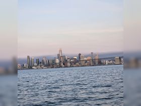 A stunning view of the San Francisco skyline at dusk, featuring the iconic Bay Bridge and shimmering waters — perfect for capturing the essence of a waterfront adventure.
