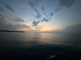 A serene sunset view over calm waters, showcasing the tranquil beauty of the sea — perfect for evening boat cruises.