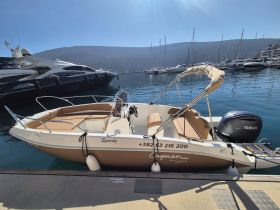 A sleek speedboat named 'Speedy' docked at a marina, showcasing its stylish design and inviting seating — perfect for a day on the water.