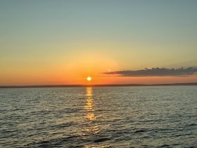 A breathtaking sunset over calm waters, creating a serene atmosphere perfect for evening boat cruises and relaxation.