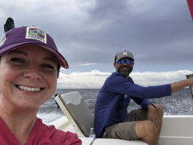 A joyful moment captured on a boat with two smiling individuals enjoying their time on the water, showcasing the thrill of boating adventures.