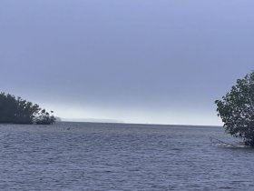A hazy view of a waterway with indistinct features, making it difficult to identify specific elements or subjects.