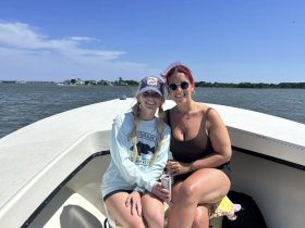 Two friends enjoy a sunny day on the boat, capturing the essence of fun and relaxation on the water.