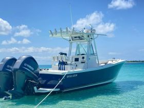 A stunning center console boat named 'Regulator' anchored in crystal-clear waters, perfect for fishing or leisure outings.