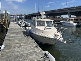 A well-equipped boat is docked at the marina, with crew members preparing for their next adventure. Ideal for fishing trips or leisurely outings on the water.