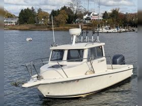 A sleek view of the '220 Admiral' boat cruising through calm waters, showcasing its design and functionality — perfect for fishing or leisure outings.