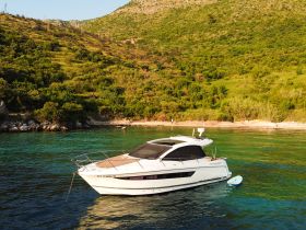 A stunning yacht anchored in clear turquoise waters, surrounded by lush greenery — perfect for exploring coastal destinations.
