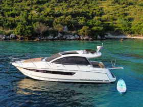 A stunning view of a sleek yacht anchored in clear turquoise waters, surrounded by lush greenery — perfect for luxury getaways or day trips on the water.