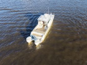 Aerial view of a Worldcat catamaran cruising through the water, showcasing its sleek design and powerful twin engines.