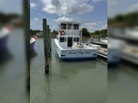 The 'Ocean City Girl' is docked at the marina, showcasing its spacious design and inviting atmosphere for fishing or leisure trips.
