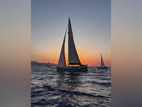 A stunning sunset view of a sailing yacht navigating the ocean, capturing the essence of a perfect evening on the water.