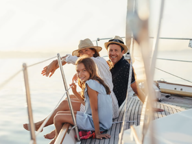A joyful family enjoys a sunset sailing experience, capturing precious moments together on the water.