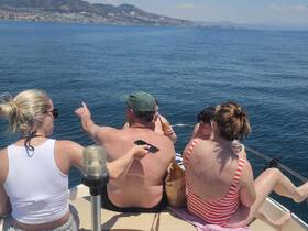 A lively group enjoys a sunny day on the water, sharing drinks and good times aboard a boat — perfect for summer celebrations and outings.
