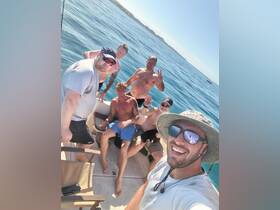 A lively group of friends enjoys a day on the water, capturing fun moments aboard their boat. Perfect for celebrating special occasions or just soaking up the sun.