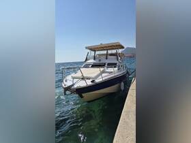 A sleek yacht docked at the shore, showcasing its elegant design against a clear blue sky and tranquil waters — perfect for luxury boating experiences.