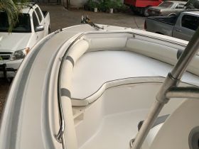 Interior view of a boat's seating area, showcasing comfortable cushions and a sleek design, perfect for relaxing while on the water.