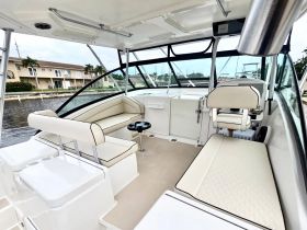 A spacious and stylish interior of a boat featuring comfortable seating and a helm area, perfect for relaxing while cruising on the water.