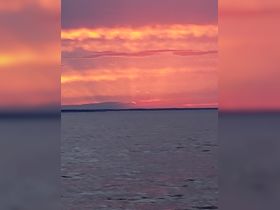 A stunning sunset paints the sky in vibrant hues over calm waters, creating a picturesque backdrop for evening boat trips.