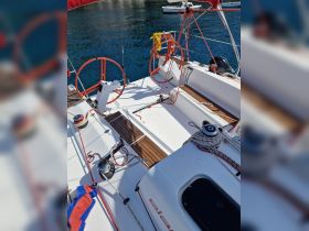 An interior view of a sailboat's helm and console area, showcasing the intricate design and equipment essential for navigation.