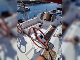 A well-equipped helm area of a sailboat, showcasing the steering wheel and console, perfect for navigating the open waters.
