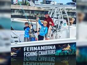 A family proudly displays their catch after a successful fishing charter, showcasing the joy of fishing with kids and the thrill of the catch.